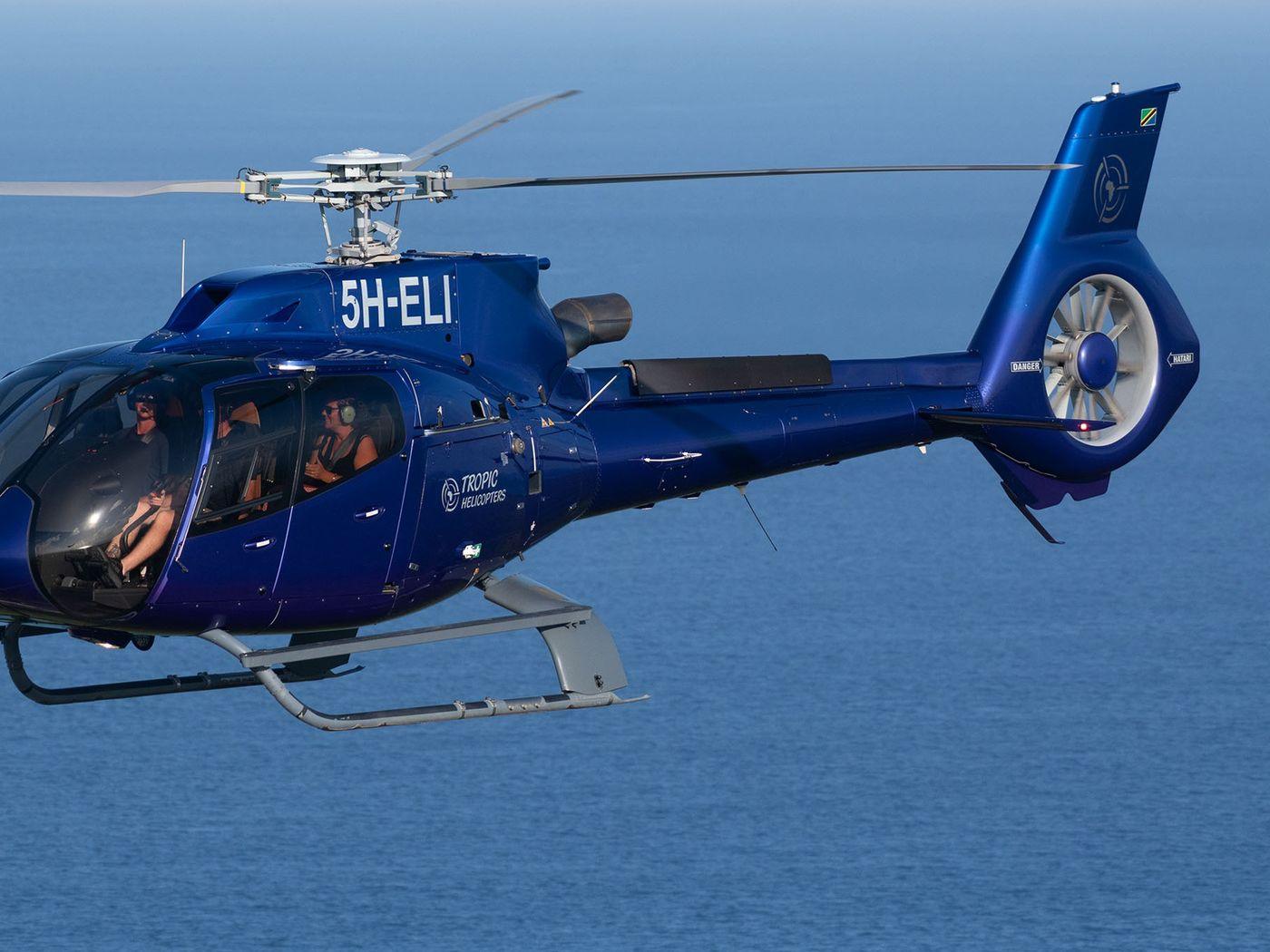 A blue helicopter flying low over the Indian Ocean