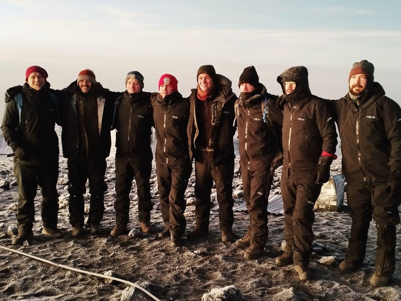 A group in down jackets at dawn high on Kilimanjaro