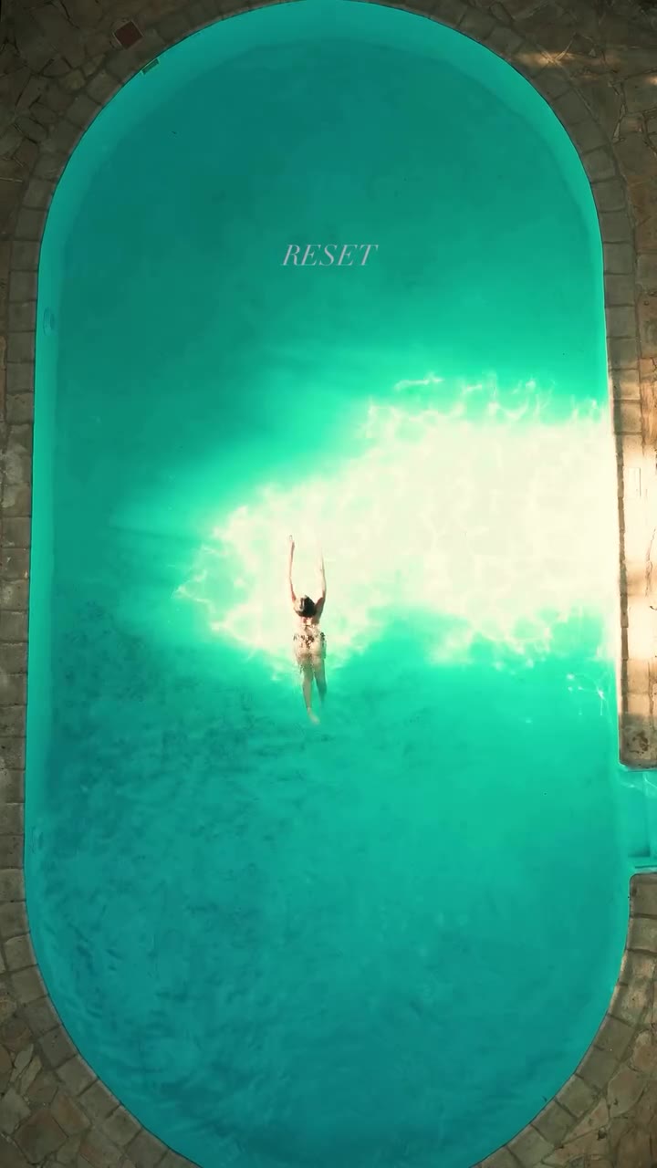 A swimmer in a turquoise pool, seen from above